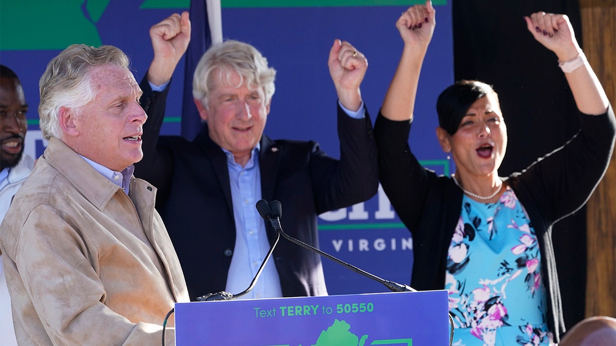 Democratic gubernatorial candidate former Gov. Terry McAuliffe, left, speaks to supporters as Attorney Gen. Mark Herring, center, and Lt. Gov. candidate Hala Ayala, right, cheer during a rally as running mates, in Richmond, Va., Monday, Nov. 1, 2021. (AP Photo/Steve Helber)