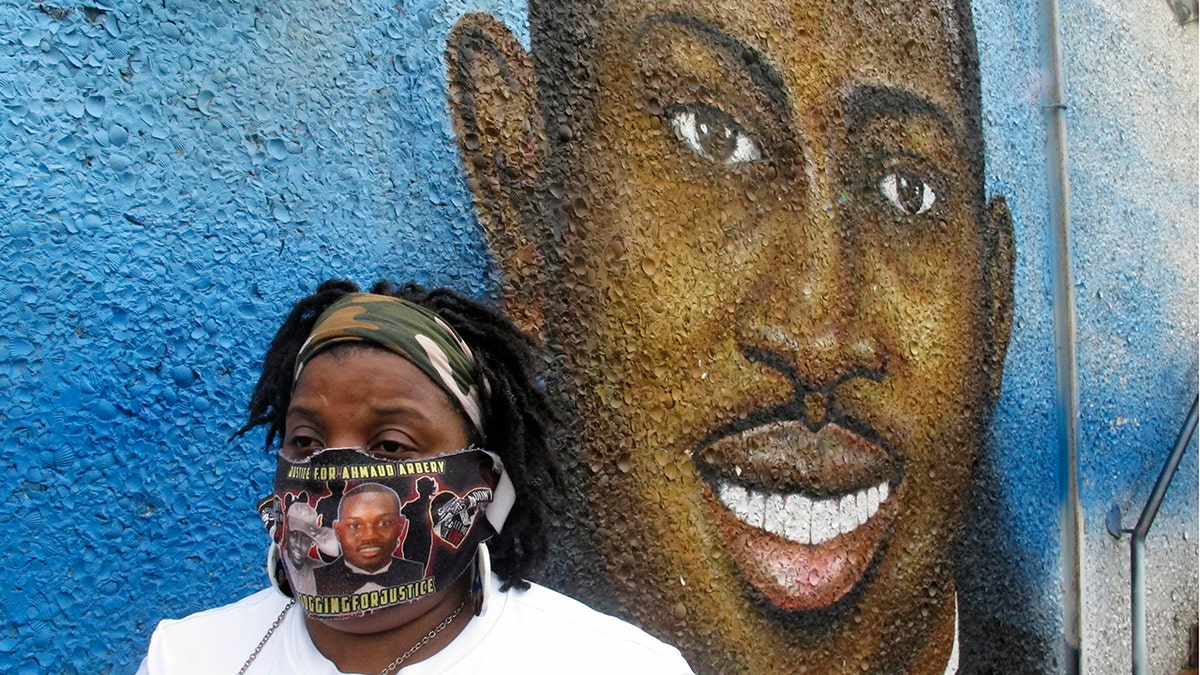 Thea Brooks stands in front of a mural of her slain nephew, Ahmaud Arbery, in Brunswick Ga. on Oct. 5, 2021.