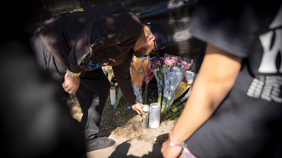 A man places a candle at a memorial in Houston for the victims of the Astroworld music festival on Sunday.