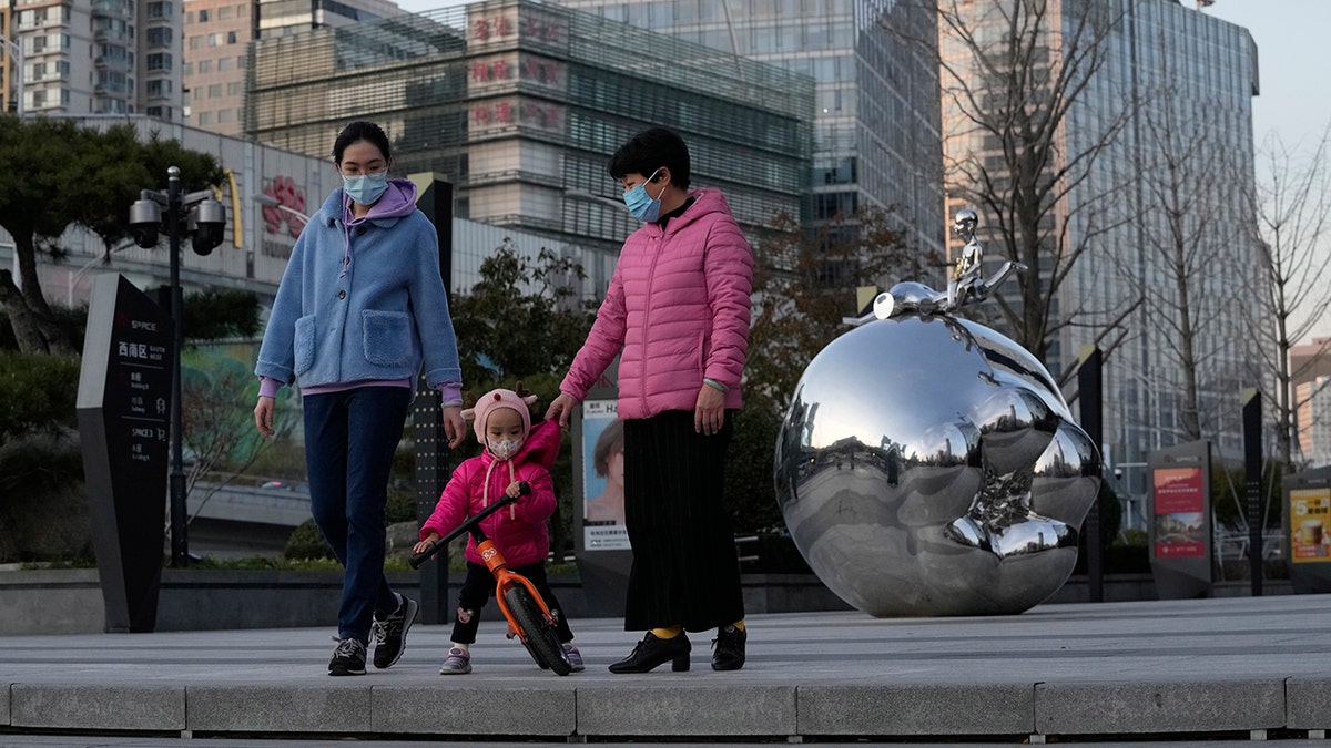 Residents wearing masks past by artwork outside a mall in Beijing, China, on Saturday.