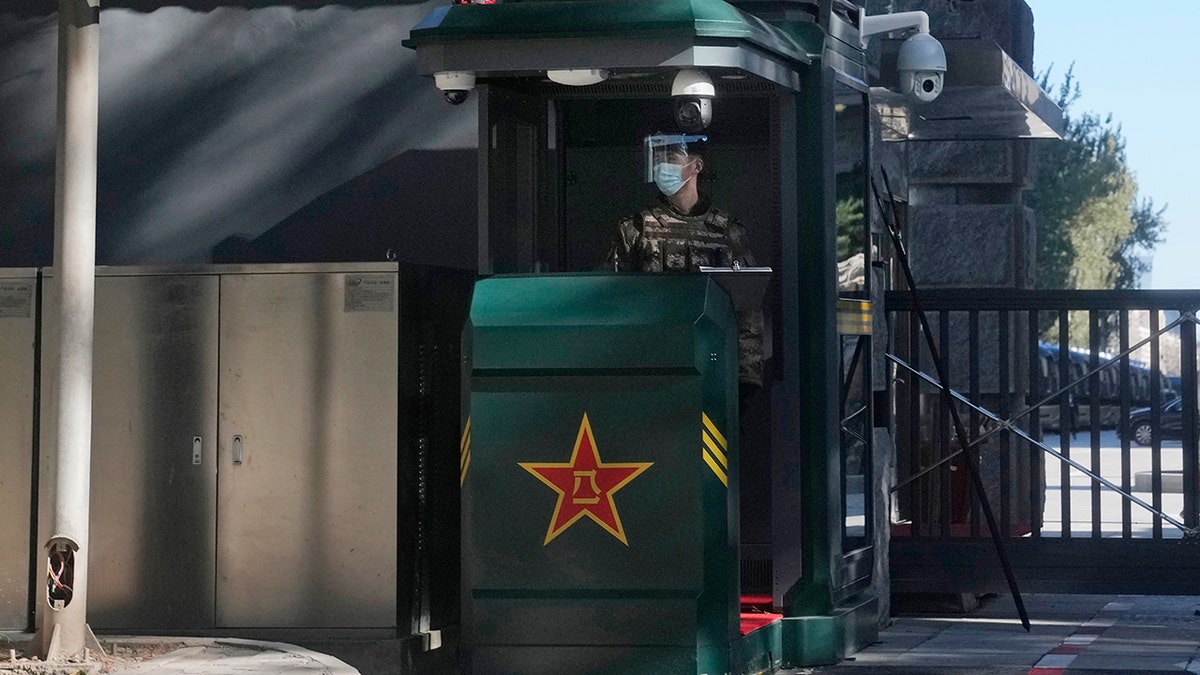 A Chinese soldier wearing a mask and face shield stands guard at the entrance to the Jingxi Hotel where roughly 200 members of the Central Committee are holding a plenary session in Beijing, China, on Thursday, Nov. 11, 2021.
