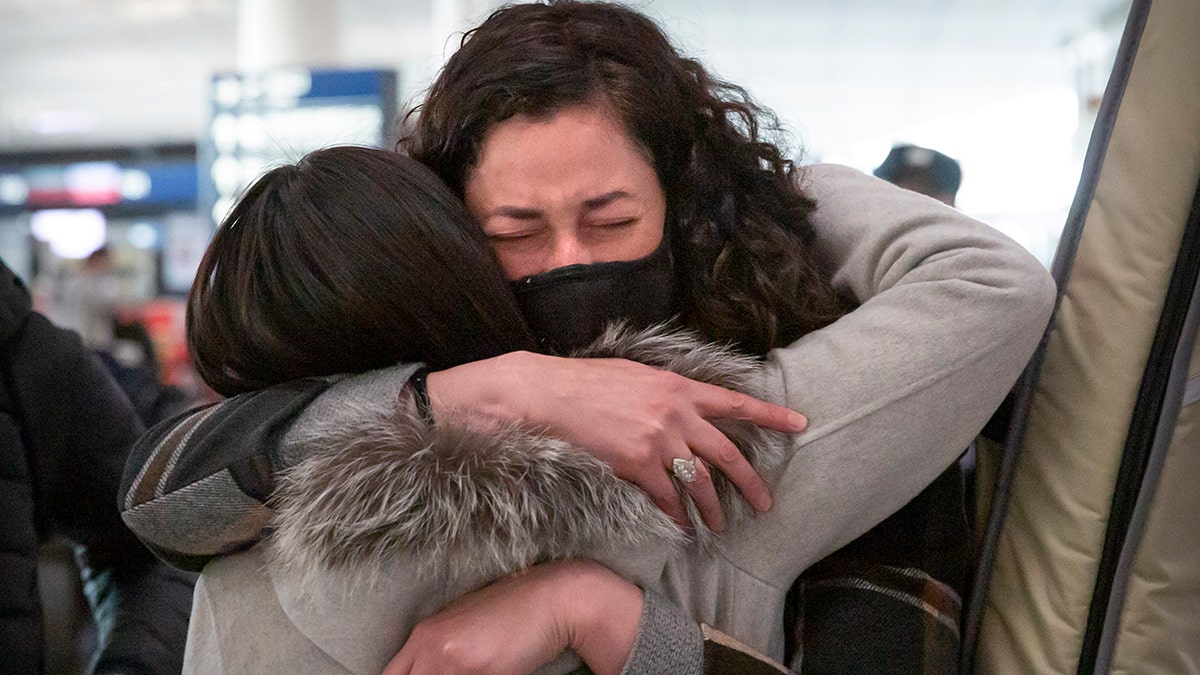 Wall Street Journal reporter Julie Wernau embraces a colleague before her departure at Beijing Capital International Airport in Beijing on March 28, 2020. 