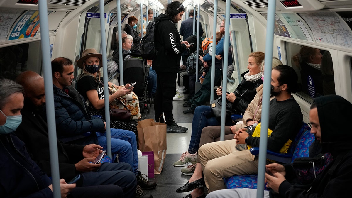 People travel on a London underground tube train on the Jubilee Line in London, Oct. 20, 2021, where face coverings are required to be worn over people's mouths and noses. 