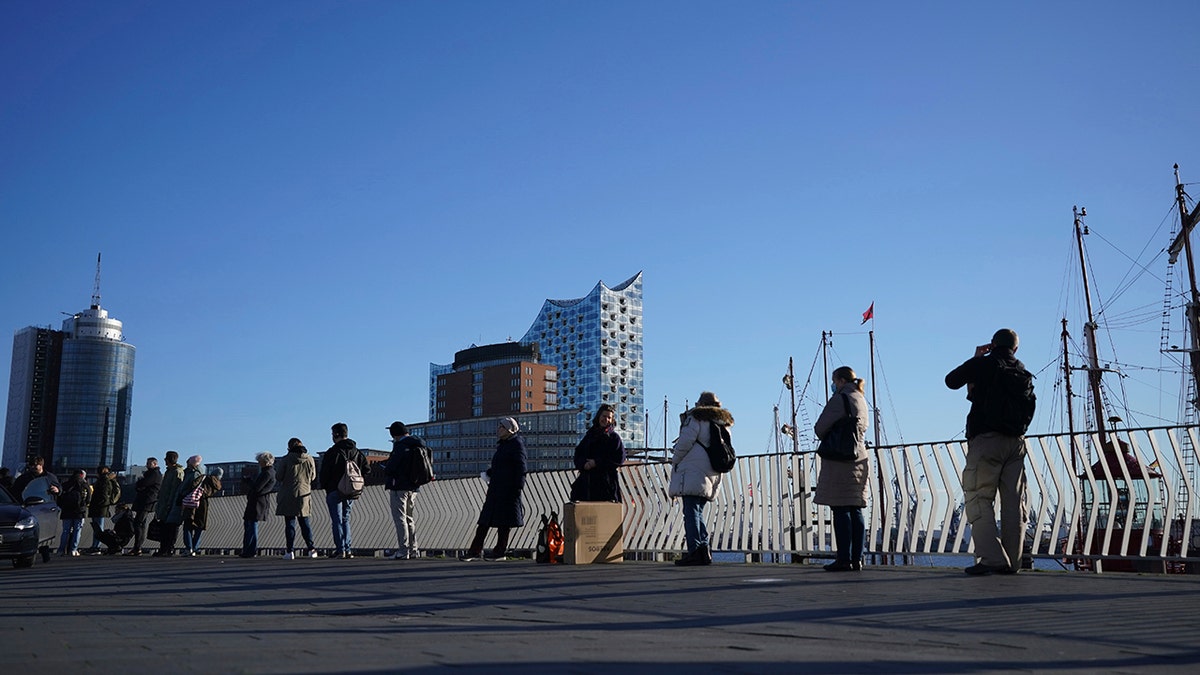 People queue up in a line several hundred meters long for the vaccination campaign at the Elbphilharmonie in Hamburg, Germany, Monday, Nov. 22, 2021.