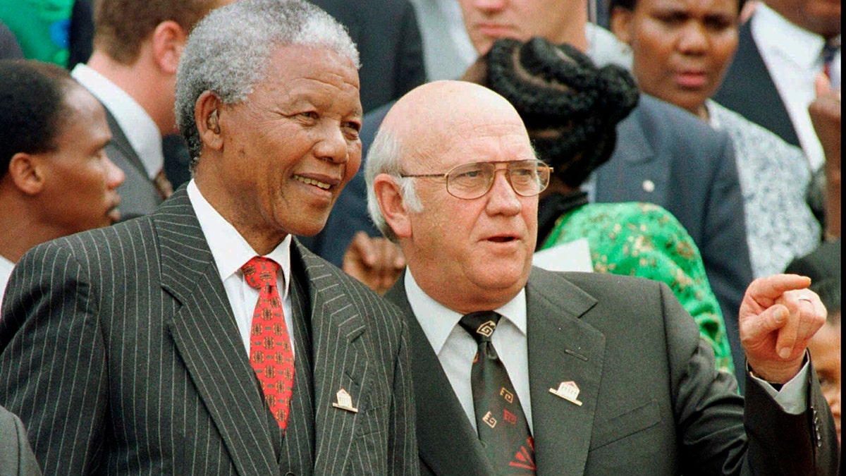 South African President Nelson Mandela, left, and Deputy President F.W. de Klerk chat outside Parliament after the approval of South Africa's new constitution in May 1996.