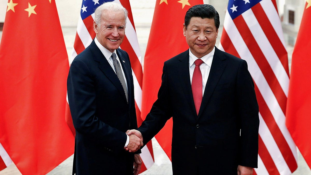 FILE PHOTO: Chinese President Xi Jinping shakes hands with U.S. Vice President Joe Biden (L) inside the Great Hall of the People in Beijing December 4, 2013. 