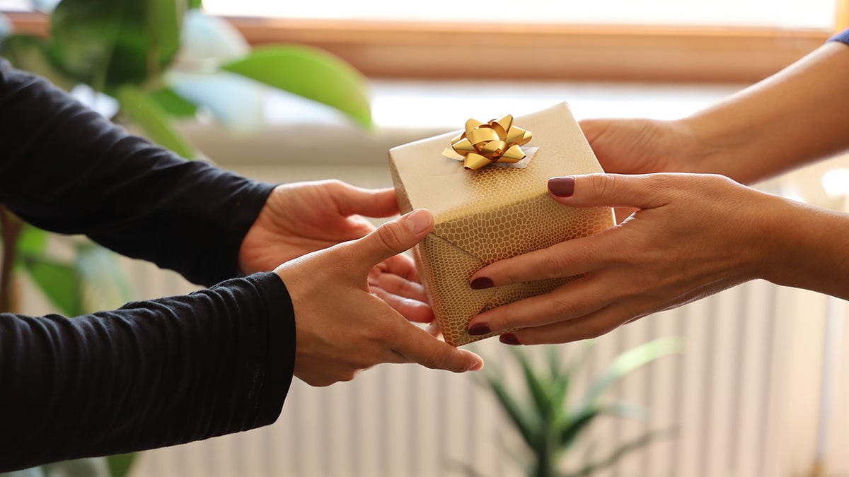 A person gives a gift to someone else