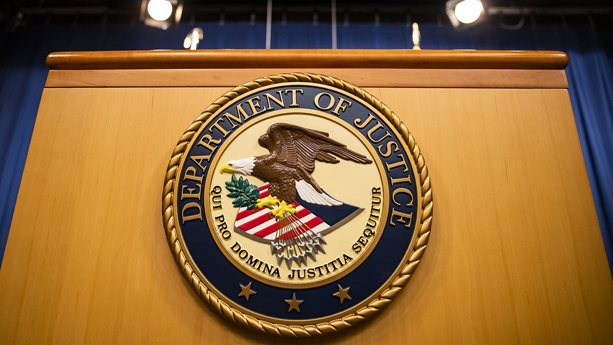 The U.S. Department of Justice seal on a podium in Washington, D.C., U.S., on Thursday, Aug. 5, 2021. The Justice Department has opened an investigation into the City of Phoenix and the Phoenix Police Department looking into types of use of force by Phoenix police department officers.