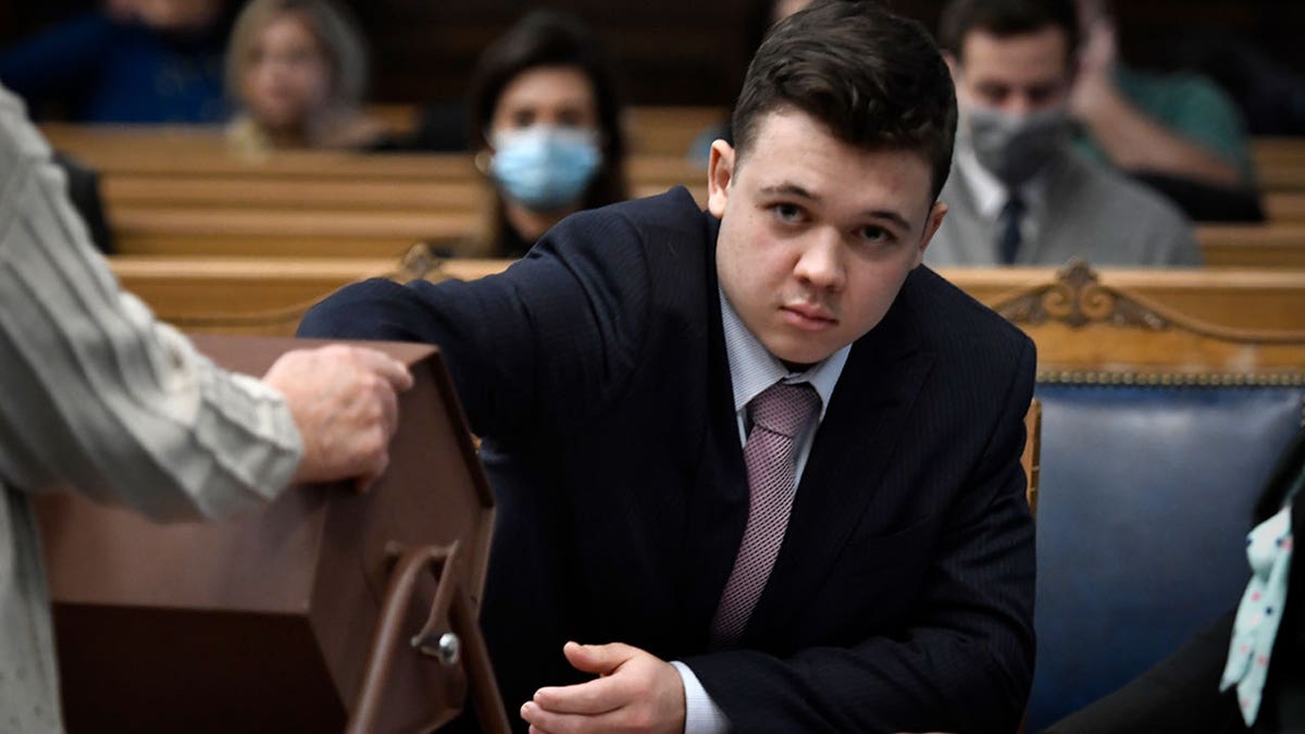 Kyle Rittenhouse pulls numbers of jurors out of a tumbler during his trial at the Kenosha County Courthouse in Kenosha