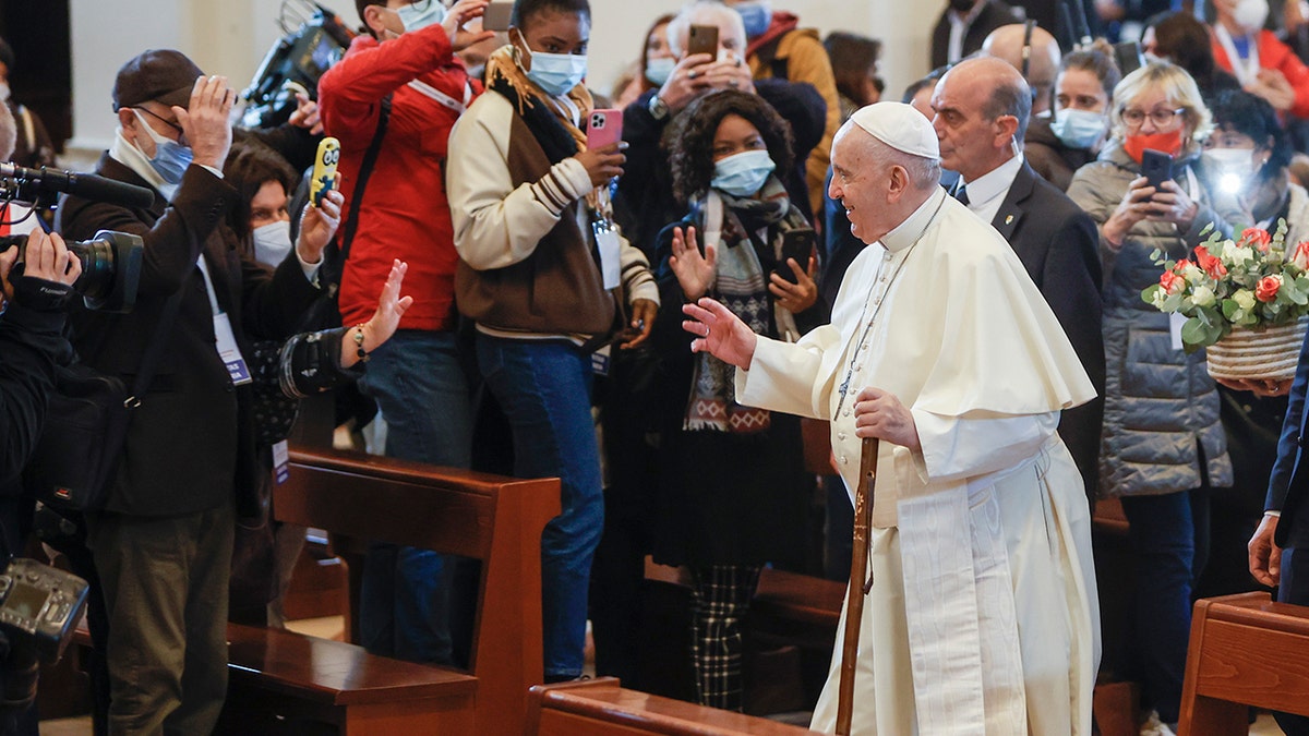 Pope Francis uses the pilgrim's walking stick he symbolically received upon his arrival to preside a meeting of listening and prayer in the Basilica of Santa Maria degli Angeli in Assisi, central Italy on Friday. 