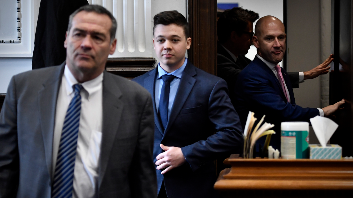 Kyle Rittenhouse, center, enters the courtroom with his attorneys Mark Richards, left, and Corey Chirafisi for a meeting called by Judge Bruce Schroeder at the Kenosha County Courthouse in Kenosha, Wisconsin. Police departments across the country said they were ensuring the right to peaceful protests following his not guilty verdict Friday.