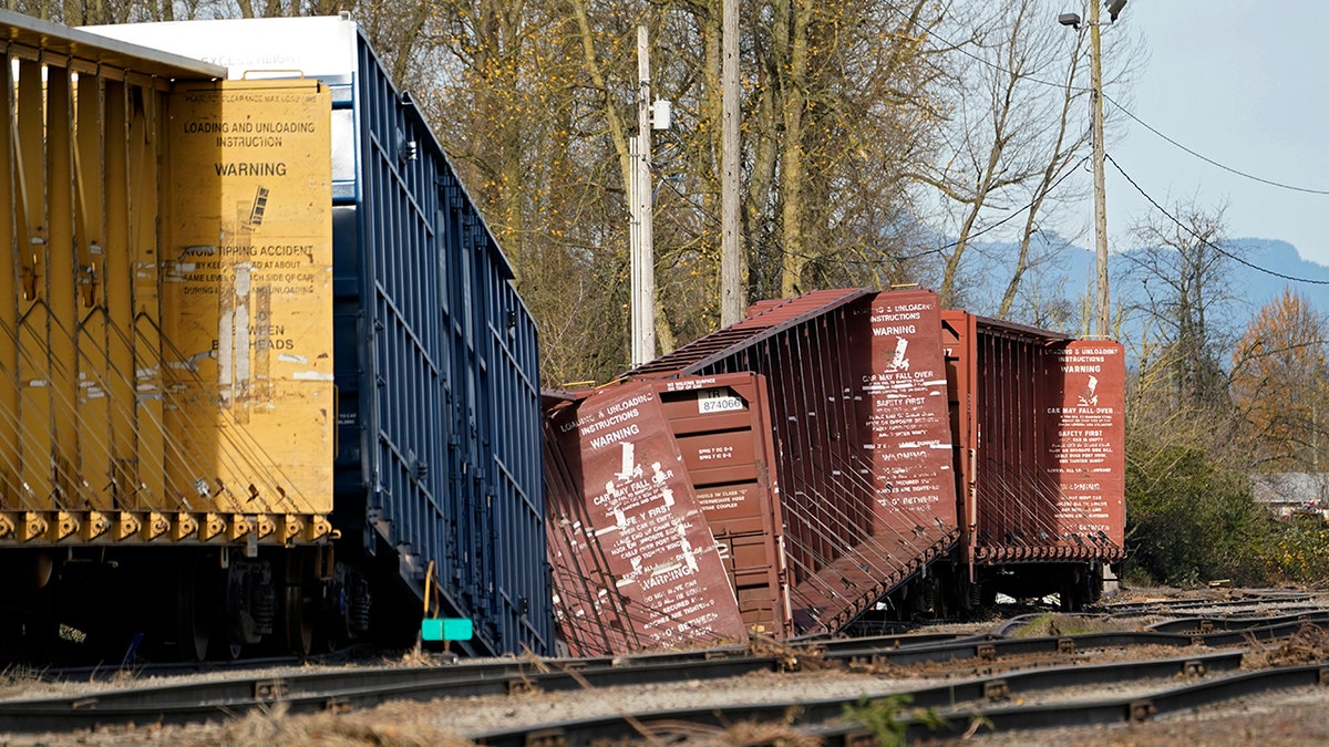 Railroad cars derailed by flooding sit near tracks at a BNSF rail yard Wednesday, Nov. 17, 2021, in Sumas, Washington. 