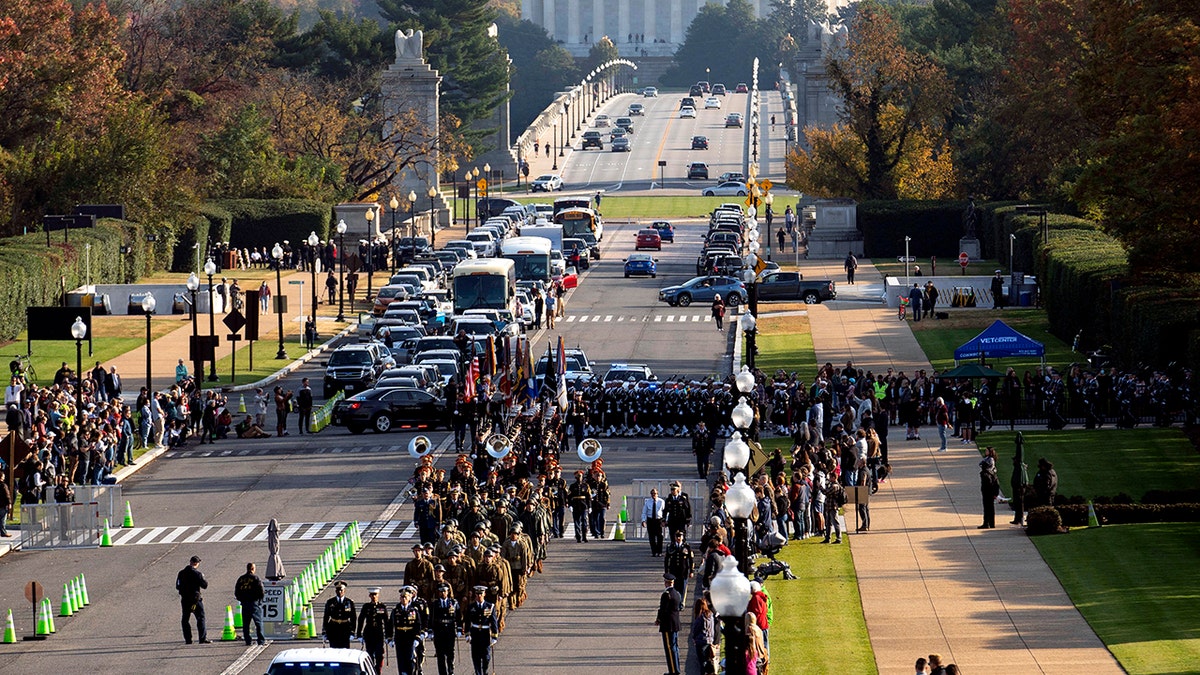 Troops march during a full honors procession honoring the centennial anniversary of the Tomb of the Unknown Soldier, Thursday, Nov. 11, 2021 at Arlington National Cemetery in Arlington, Va. The Lincoln Memorial in Washington is shown in the distance. 