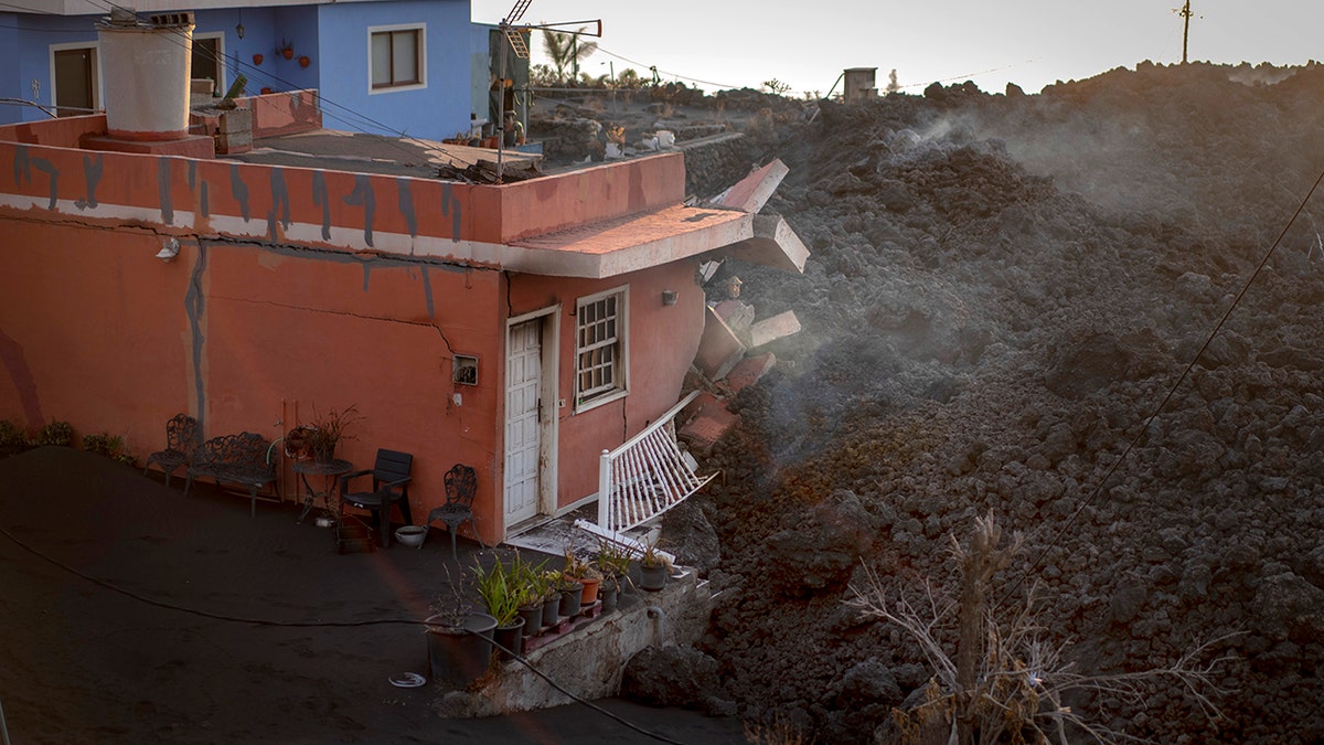 Lava destroys a house as the volcano continues to erupt on the Canary island of La Palma, Spain, on Tuesday.