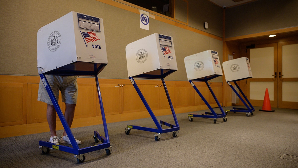 A voter stands in a booth at a voting station at the Metropolitan Museum of Art (MET) during the mayoral election process in New York on June 12, 2021. 