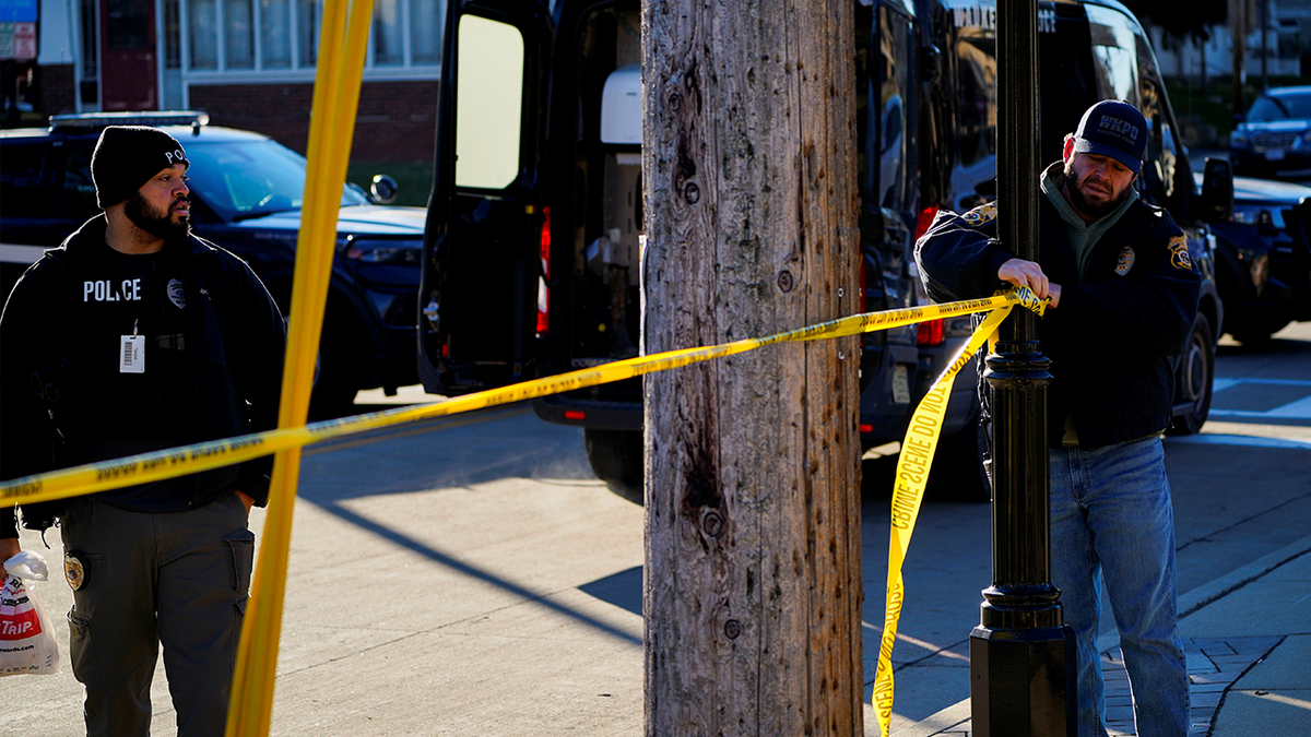 Police officers close a street in downtown Waukesha the morning after a car plowed through a holiday parade in Waukesha, Wisconsin, U.S., November 22, 2021.