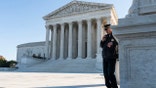 A police officer maintains a watch during a demonstration by victims of gun violence in front of the Supreme Court as arguments begin in a major case on gun rights on Nov. 3, 2021 in Washington, D.C.  (Photo by Joshua Roberts/Getty Images)