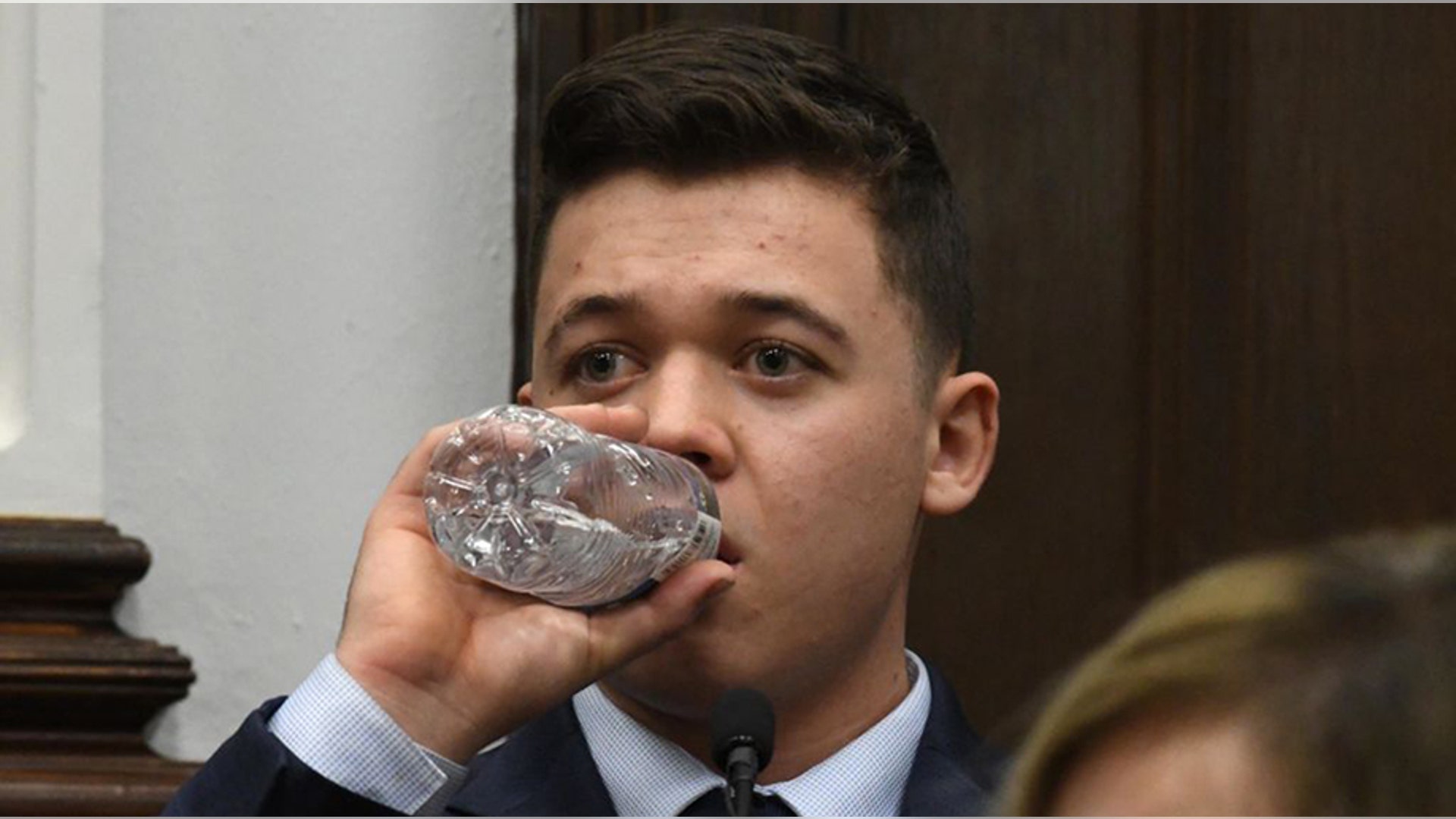 KENOSHA, WISCONSIN - NOVEMBER 10: Kyle Rittenhouse takes a drink of water while testifying during his trial at the Kenosha County Courthouse on November 10, 2021 in Kenosha, Wisconsin. Rittenhouse shot three demonstrators, killing two of them, during a night of unrest that erupted in Kenosha after a police officer shot Jacob Blake seven times in the back while police attempted to arrest him in August 2020. Rittenhouse, from Antioch, Illinois, was 17 at the time of the shooting and armed with an assault rifle. He faces counts of felony homicide and felony attempted homicide. (Photo by Mark Hertzberg-Pool/Getty Images)