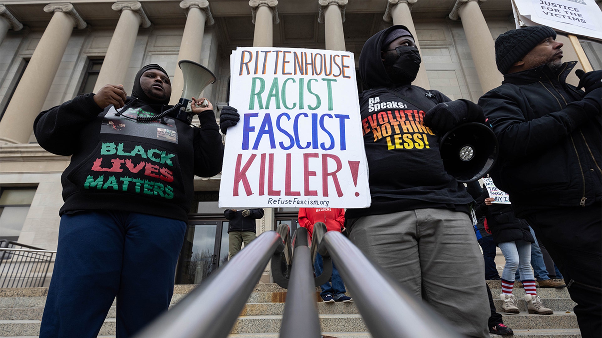 Demonstrators hold signs outside of the Kenosha County Courthouse during closing arguments in the Kyle Rittenhouse trial in Kenosha, Wisconsin, U.S., on Tuesday, Nov. 16, 2021. Rittenhouse, 18, is accused of homicide in the deaths of Joseph Rosenbaum and Anthony Huber, as well as attempted homicide for shooting Gaige Grosskreutz. Photographer: Christian Monterrosa/Bloomberg via Getty Images