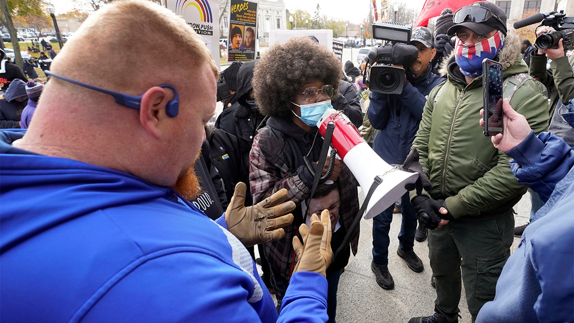 Protesters argue outside the Kenosha County Courthouse, Tuesday, Nov. 16, 2021, in Kenosha, Wis., during the Kyle Rittenhouse murder trial. Rittenhouse is accused of killing two people and wounding a third during a protest over police brutality in Kenosha, last year. (AP Photo/Paul Sancya)