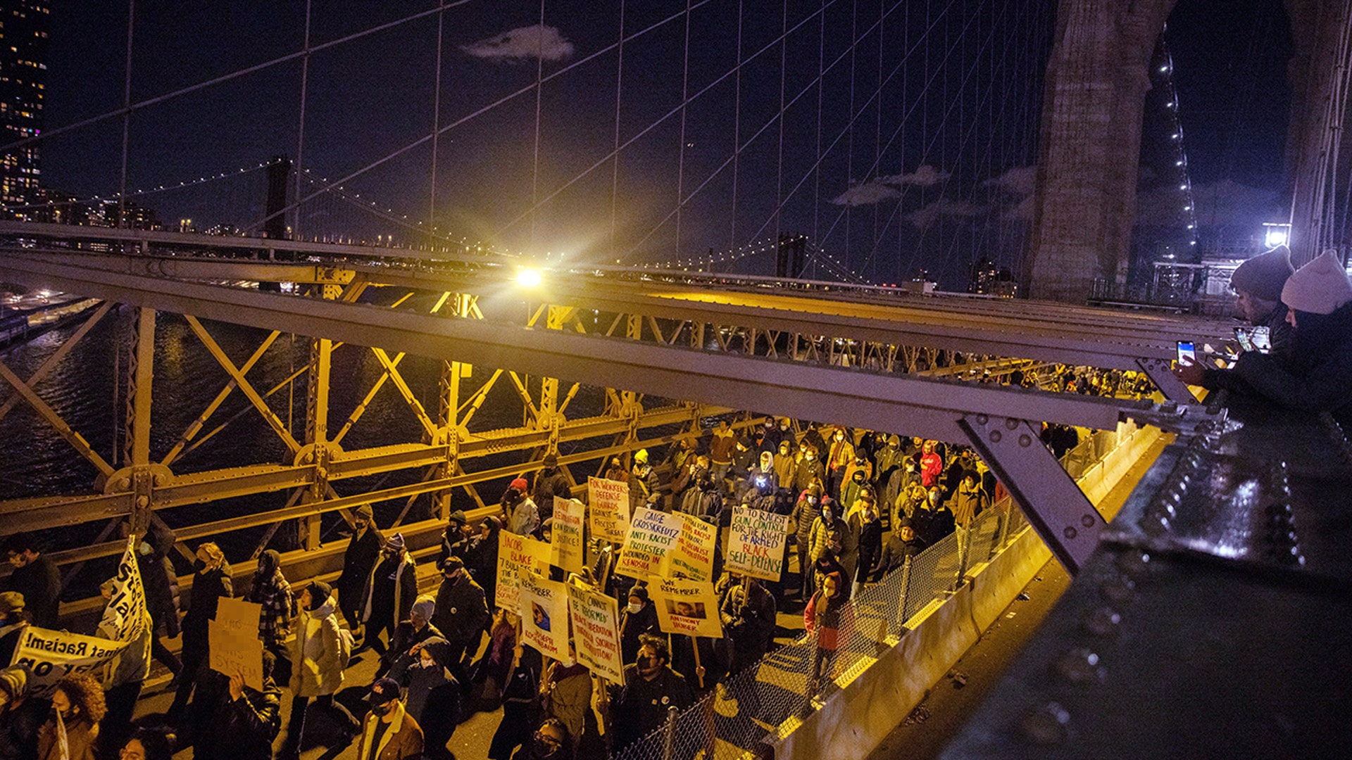 Demonstrators march across the Brooklyn Bridge Friday, Nov. 19, 2021, in New York, following the acquittal of Kyle Rittenhouse in Kenosha, Wis.