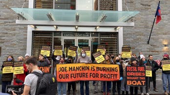 Climate group protests outside of where Manchin docks his houseboat