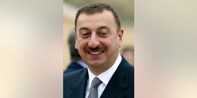 Then-newly elected president of Azerbaijan Ilham Aliyev smiles as he answers journalists' questions in Baku, Oct. 18, 2003.  (REUTERS/Gleb Garanich AS/WS)