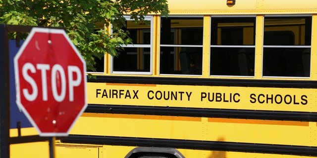 A Fairfax County school bus sits in a depot, a day after it was announced the county would begin the school year all online, in Lorton, Virginia.