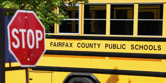 A Fairfax County school bus sits in a depot, a day after it was announced the county would begin the school year all online, Virginia, 2020. 