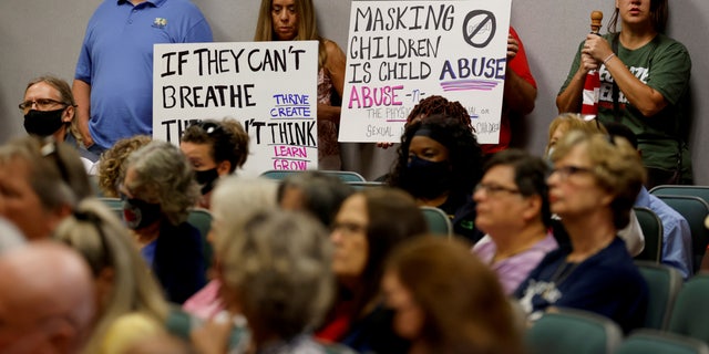 FILE PHOTO: People hold placards as members of the Lake County School Board conduct an emergency meeting to discuss mask mandates to prevent the spread of coronavirus disease (COVID-19) in Tavares, Florida, U.S., September 2, 2021.  REUTERS/Joe Skipper/File Photo