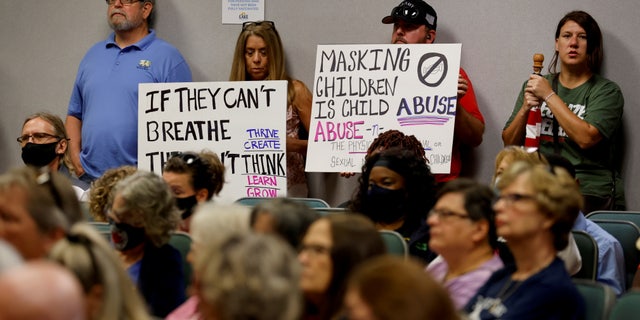 People hold placards as members of the Lake County School Board conduct an emergency meeting to discuss mask mandates in Tavares, Florida, on Sept. 2, 2021. (Reuters/Joe Skipper/File Photo)