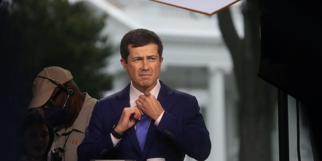 U.S. Secretary of Transportation Pete Buttigieg prepares to give a live interview to the news media outside of the White House in Washington, U.S., October 13, 2021. REUTERS/Leah Millis