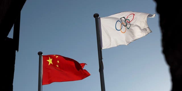 Las banderas china y olímpica ondean en la sede del Comité Organizador de Beijing para los Juegos Olímpicos y Paralímpicos de Invierno 2022 en Beijing, China, el 12 de noviembre de 2021.