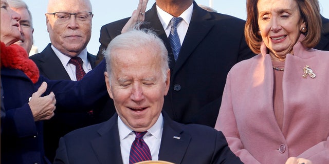 President Biden celebrates with lawmakers, including ‪House Speaker Nancy Pelosi, before signing the Infrastructure Investment and Jobs Act at the White House, Nov. 15, 2021. 