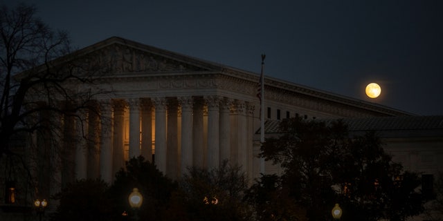 A full moon rises behind the U.S. Supreme Court on Capitol Hill in Washington, U.S., November 18, 2021. REUTERS/Tom Brenner
