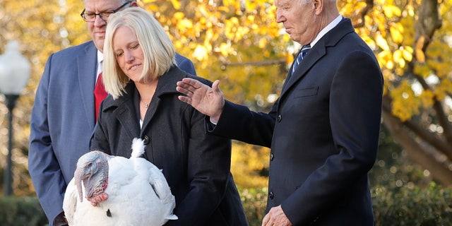 U.S. President Joe Biden pardons the national Thanksgiving turkey, Peanut Butter, as Phil Seger, chairman of the National Turkey Federation, and Andrea Welp, a turkey grower from Indiana, stand by during the 74th National Thanksgiving Turkey Presentation in the Rose Garden at the White House in Washington, U.S., November 19, 2021. REUTERS/Jonathan Ernst