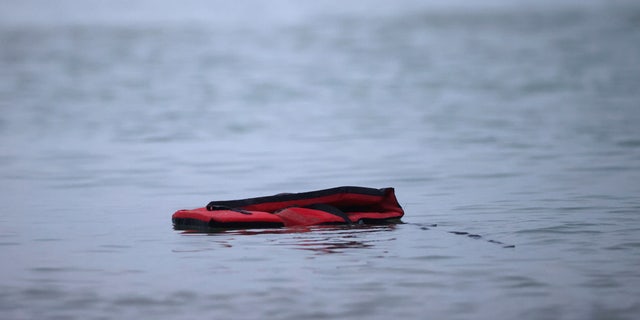 A life jacket is left after a group of more than 40 migrants get on an inflatable dinghy, to leave the coast of northern France and to cross the English Channel, near Wimereux, France, November 24, 2021. REUTERS/Gonzalo Fuentes