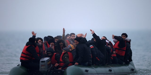 A group of more than 40 migrants react as they succeeded to get on an inflatable dinghy, to leave the coast of northern France and to cross the English Channel, near Wimereux, France, November 24, 2021. REUTERS/Gonzalo Fuentes