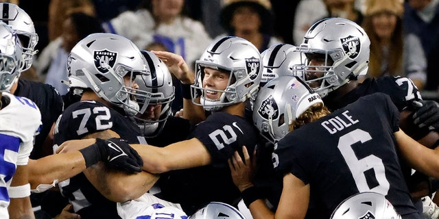 Las Vegas Raiders place kicker Daniel Carlson (2) is congratulated by Jermaine Eluemunor (72), AJ Cole (6) and others after Carlson kicked a game-winning field goal in overtime of an NFL football game against the Dallas Cowboys in Arlington, テキサス, 木曜日, 11月. 25, 2021.