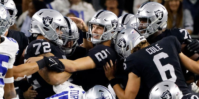 Las Vegas Raiders place kicker Daniel Carlson (2) is congratulated by Jermaine Eluemunor (72), AJ Cole (6) and others after Carlson kicked a game-winning field goal in overtime of an NFL football game against the Dallas Cowboys in Arlington, 德州, 星期四, 十一月. 25, 2021.
