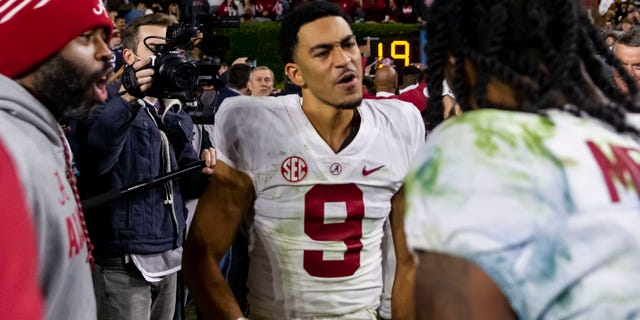 Alabama quarterback Bryce Young (9) celebrates with Alabama wide receiver John Metchie III (8) after a 24-22 4-overtime win over Auburn in an NCAA college football game, Saturday, Nov. 27, 2021, in Auburn, Ala.