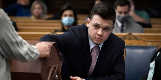 Kyle Rittenhouse pulls numbers of jurors out of a tumbler during his trial at the Kenosha County Courthouse in Kenosha, Wis., on Nov. 16, 2021.