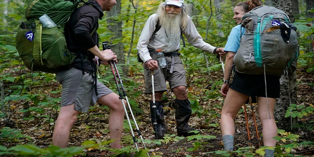 M.J. Eberhart, 83, center, shares trail information with a pair of thru-hikers on the Appalachian Trail, Sunday, Sept. 12, 2021, in Gorham, New Hampshire. Eberhart, who goes by the trail name of Nimblewill Nomad, is the oldest person to hike the entire 2,193-mile Appalachian Trail. (AP Photo/Robert F. Bukaty)