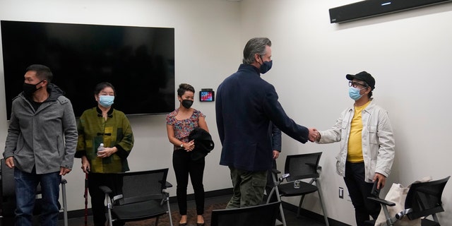 Gov. Gavin Newsom, middle right, greets patients before he received a Moderna COVID-19 vaccine booster shot at Asian Health Services in Oakland, Calif., Wednesday, Oct. 27, 2021. (AP Photo/Jeff Chiu)