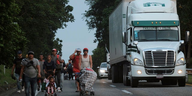 Migrants leave Ulapa, Chiapas state, late Saturday, Oct. 30, 2021. The migrant caravan heading north in southern Mexico has so far been allowed to walk unimpeded, a change from the Mexican government's reaction to other attempted mass migrations. (AP Photo/Isabel Mateos)