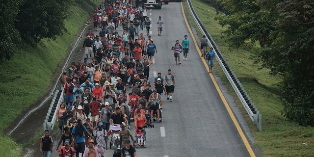 Migrants leave Ulapa, Chiapas state, late Saturday, Oct. 30, 2021. The migrant caravan heading north in southern Mexico has so far been allowed to walk unimpeded, a change from the Mexican government's reaction to other attempted mass migrations. (AP Photo/Isabel Mateos)