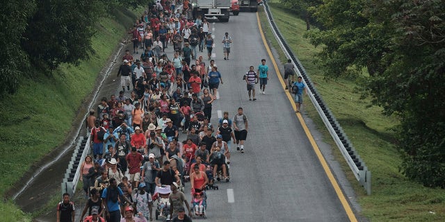 Migrants leave Ulapa, Chiapas state, late Saturday, Oct. 30, 2021. The migrant caravan heading north in southern Mexico has so far been allowed to walk unimpeded, a change from the Mexican government's reaction to other attempted mass migrations. (AP Photo/Isabel Mateos)
