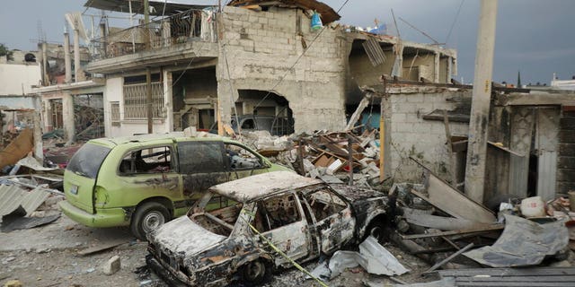 Destroyed homes and vehicles are seen after a series of explosions at a neighborhood in Puebla, Mexico, Sunday, Oct. 31, 2021. Officials say an illegal tap on a gas line is apparently to blame for the early morning explosions that killed at least one person and injured more than a dozen, destroying dozens of homes and causing the evacuation of some 2000 persons. (AP Photo/Pablo Spencer)