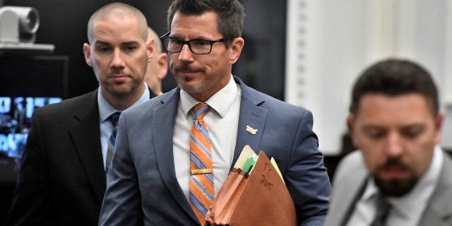 Assistant District Attorney Thomas Binger, center, makes his way into the courtroom for jury selection for the Kyle Rittenhouse trial at the Kenosha County Courthouse in Kenosha, Wis, on Monday, Nov. 1, 2021. Rittenhouse is accused of killing two people and wounding a third during a protest over police brutality in Kenosha, last year. (Sean Krajacic/The Kenosha News via AP, Pool)