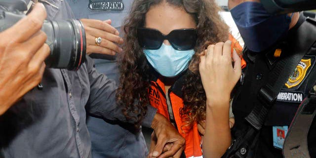 Heather Mack of Chicago, Ill., center, escorted by immigration officers to Immigration detention center in Jimbaran, Bali, Indonesia on Friday, Oct. 29, 2021. 